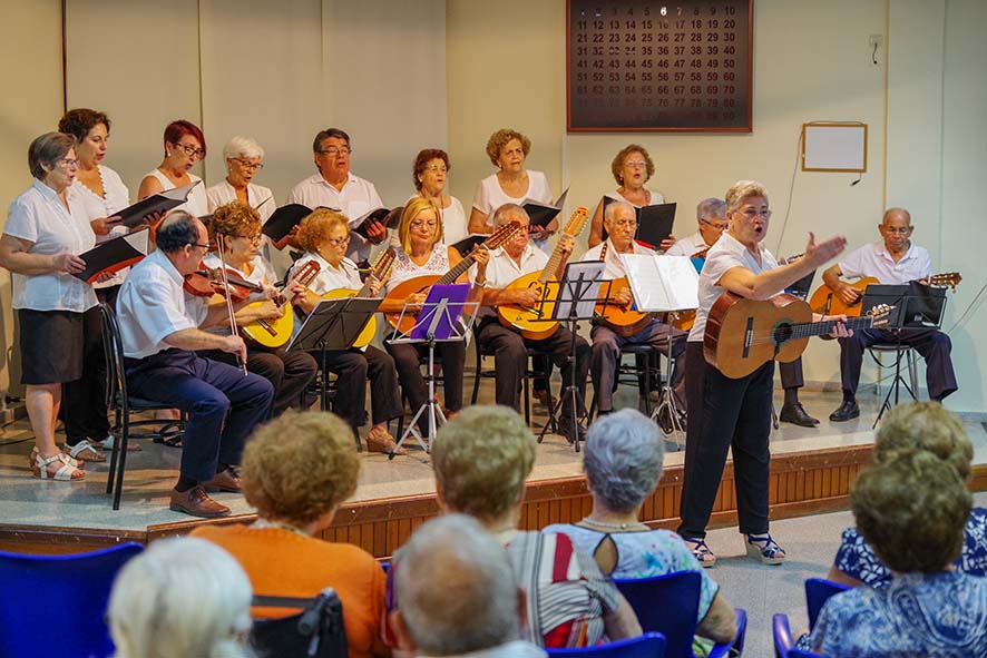 Rondalla y coro actuando ante el público en un salón